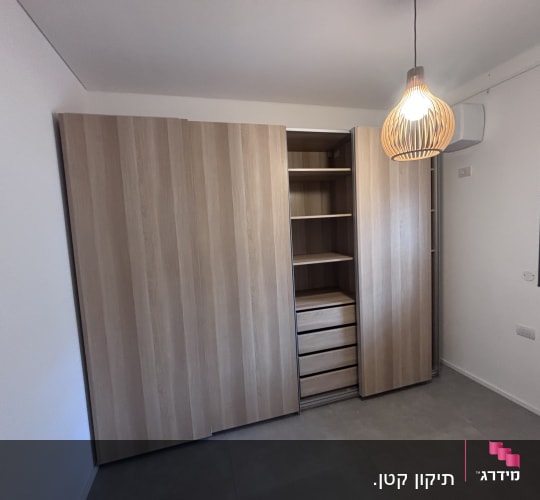 ארון עץ עם מדפים ומגירות בחדר מואר